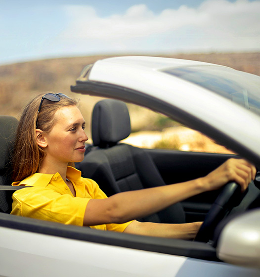 A right close up of a yellow Mercedes AMG sports car headlight on a city street